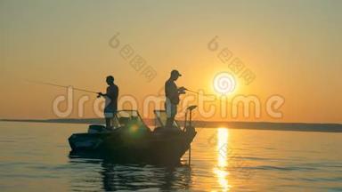 两名渔民在日出时站在船上捕鱼